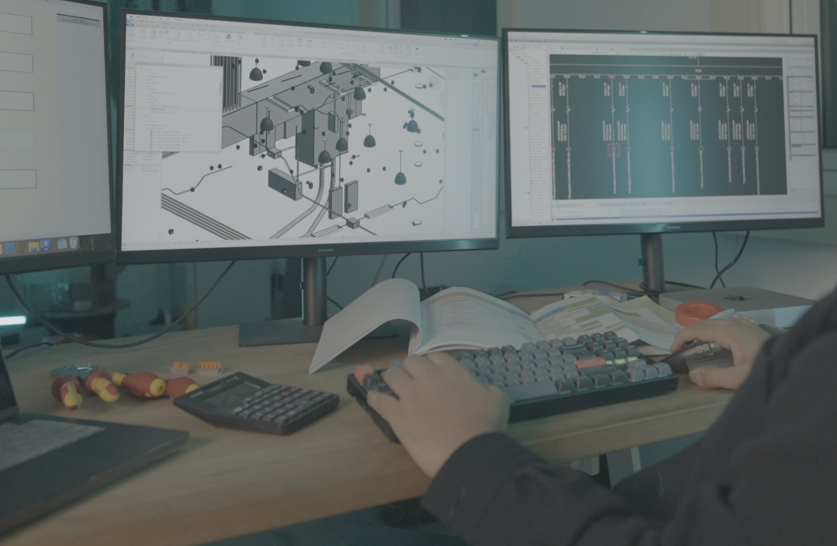 An electrical designer working on a BIM electrical model and single-line diagram across dual monitors