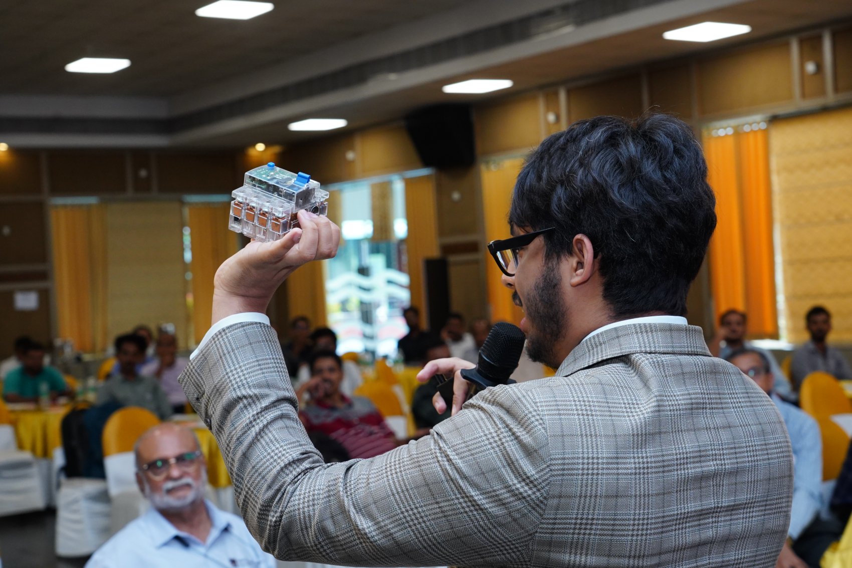 A ProtegoPlus specialist presenting a protective device to a workshop audience